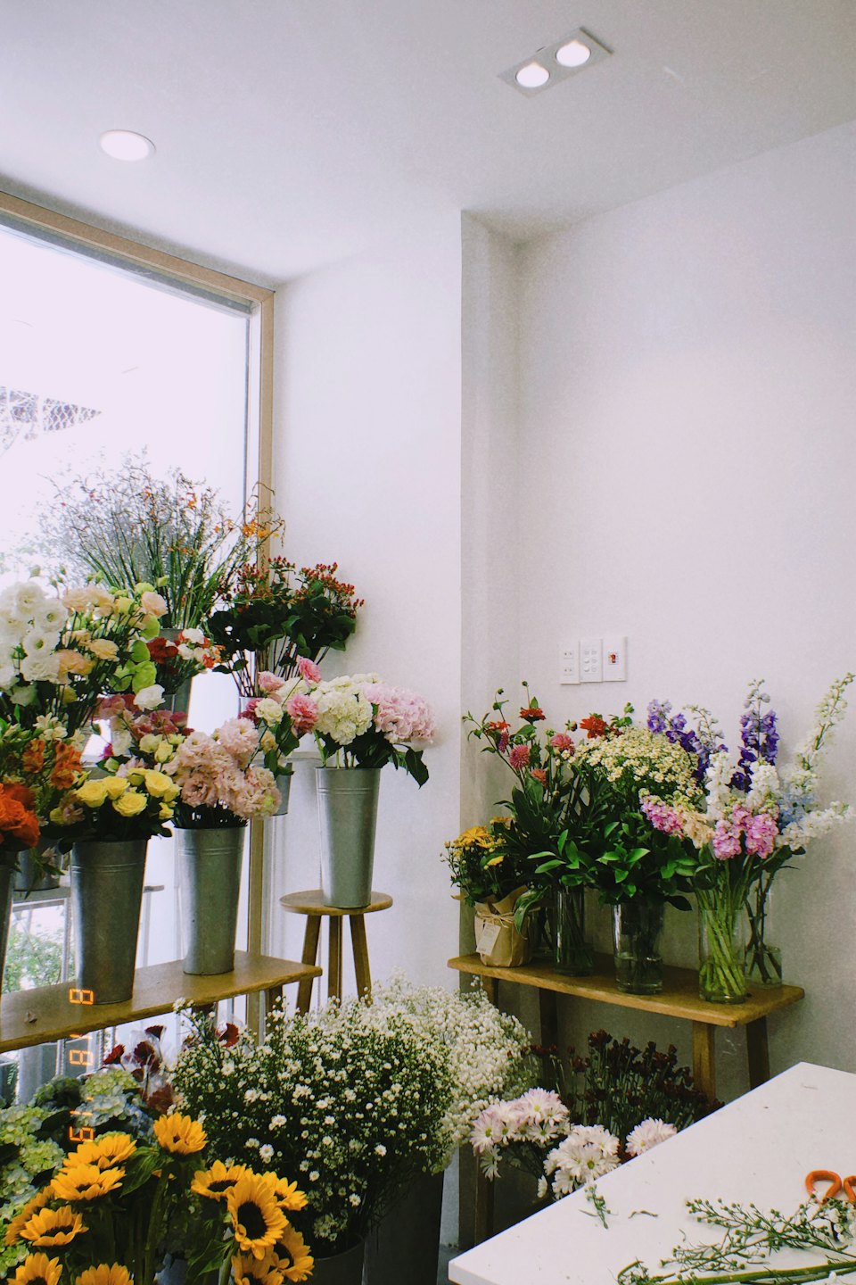 Blumenladen mit frischen Schnittblumen in Eimern und Vasen.